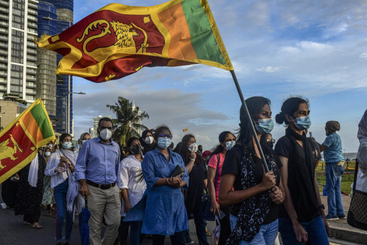 Protesters carrying the Sri Lanka flag march in the Galle Face Green area of Colombo, Sri Lanka, May 17, 2022. With no end in sight to the national economic crisis that led them to take to the streets, protesters in Sri Lanka are digging in against a president they blame for crashing the economy.  (Atul Loke/The New York Times)
